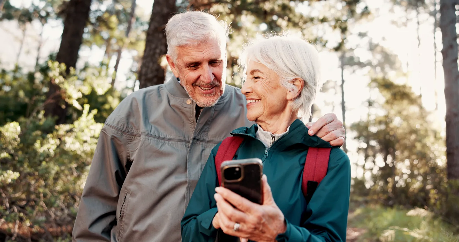 Zwei Besucher nutzen draußen gemeinsam ein Smartphone