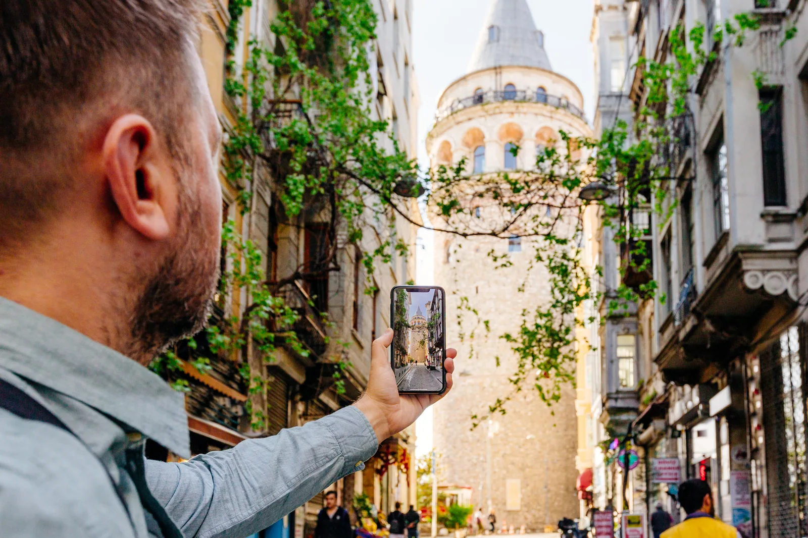 Besucher richtet sein Smartphone auf einen historischen Turm