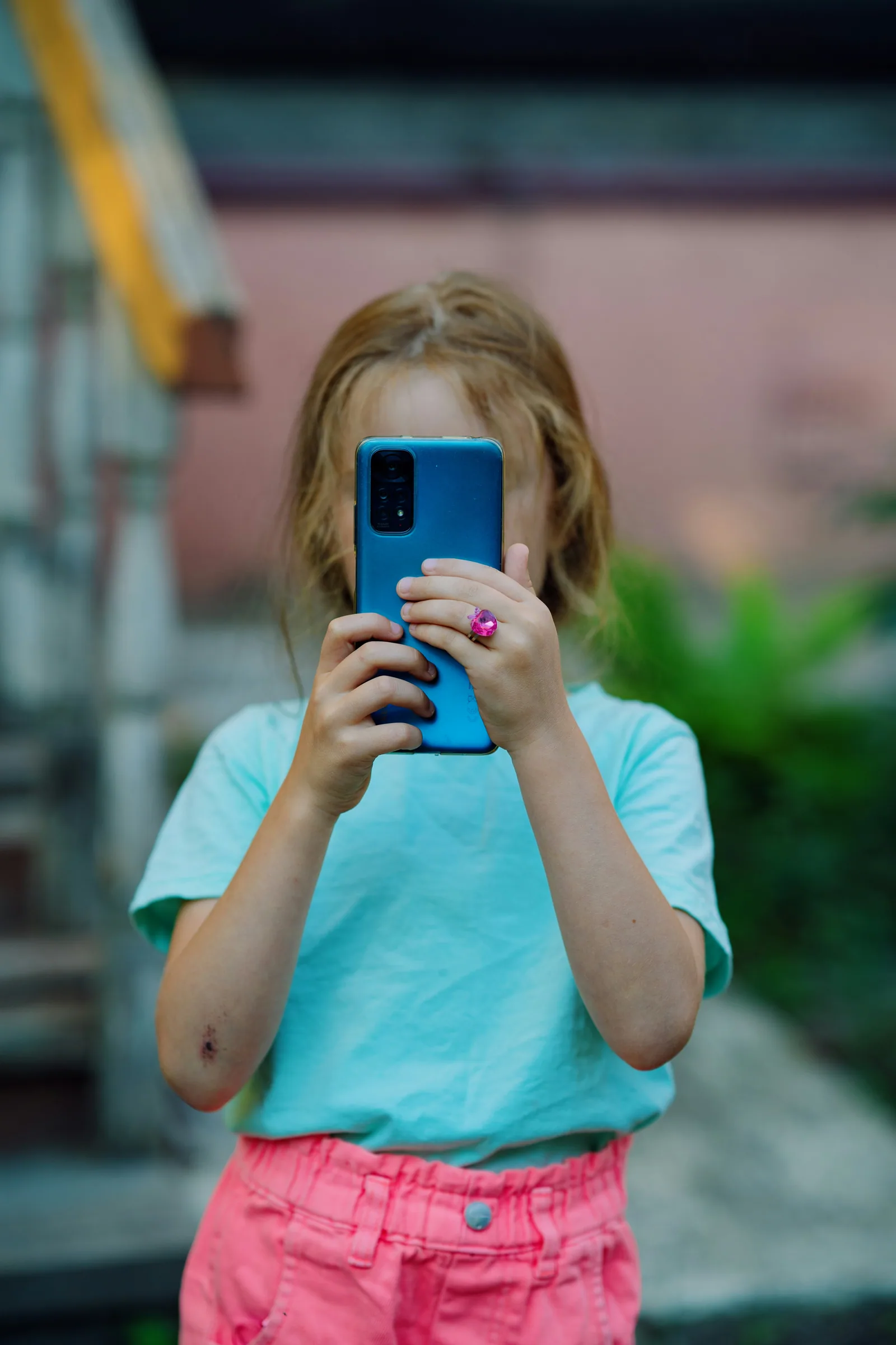 Kind betrachtet ein Detail durch die Kamera eines Smartphones