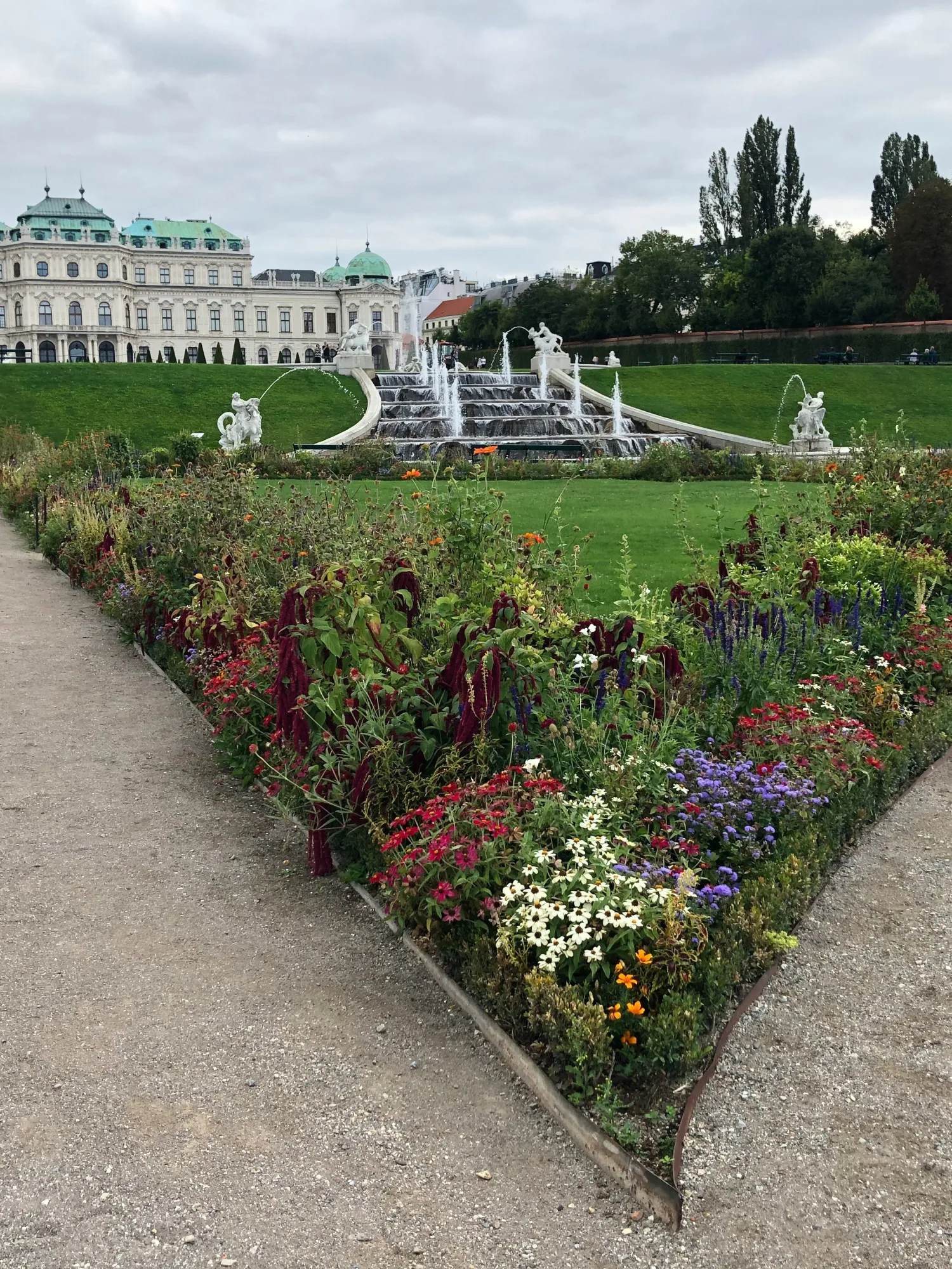 Historischer Landschaftsgarten mit Blumenbeet, Brunnen und Schlossanlage